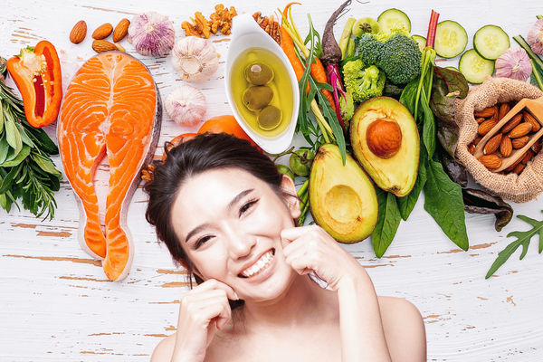 smiling woman with radiant skin in front of healthy food