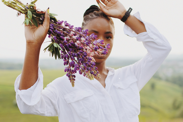 Allergy-sufferer outdoors holding bouquet of flowers, naturally symptom-free