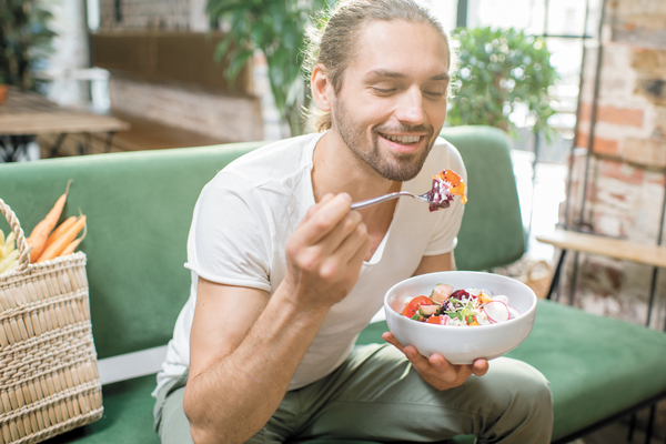 Depression patient sitting on couch eating healthy foods to help naturally improve mental health