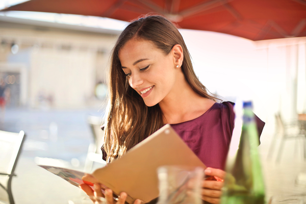 Person sitting at table at restaurant looking at menu